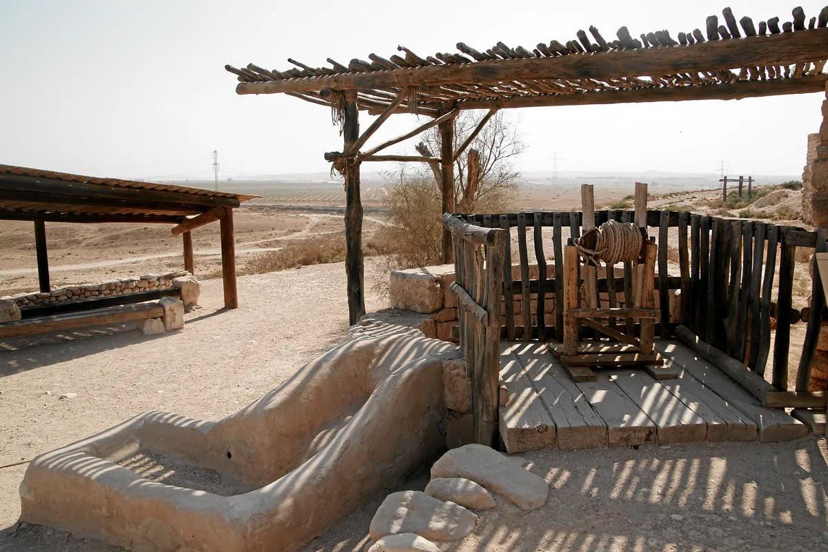 The great well of Tel Be'er Sheva under a wooden shelter, with a stone trough in the foreground