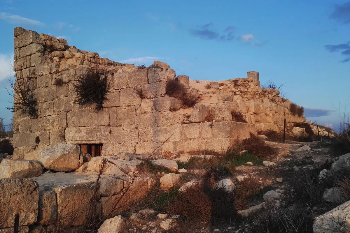 Section of dressed-stone wall at Burj Beitin under a blue sky