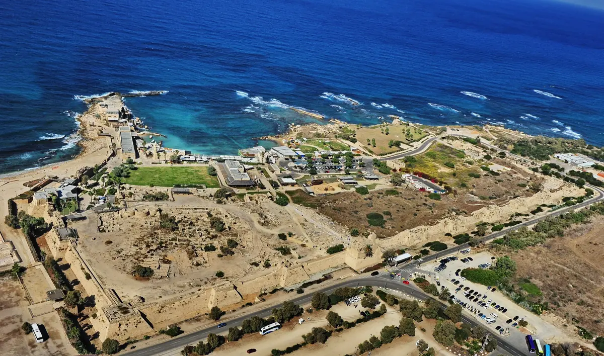 מבט אווירי על הנמל העתיק של קיסריה ועל העיר הצלבנית המוקפת חומה וחפיר, והים הכחול ברקע