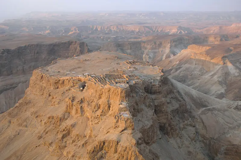 מדרגות הארמון הצפוני של מצדה הנאחזות בקצה הצוק, עם גרמי מדרגות מתכת, מעל ערוצי המדבר הבהירים