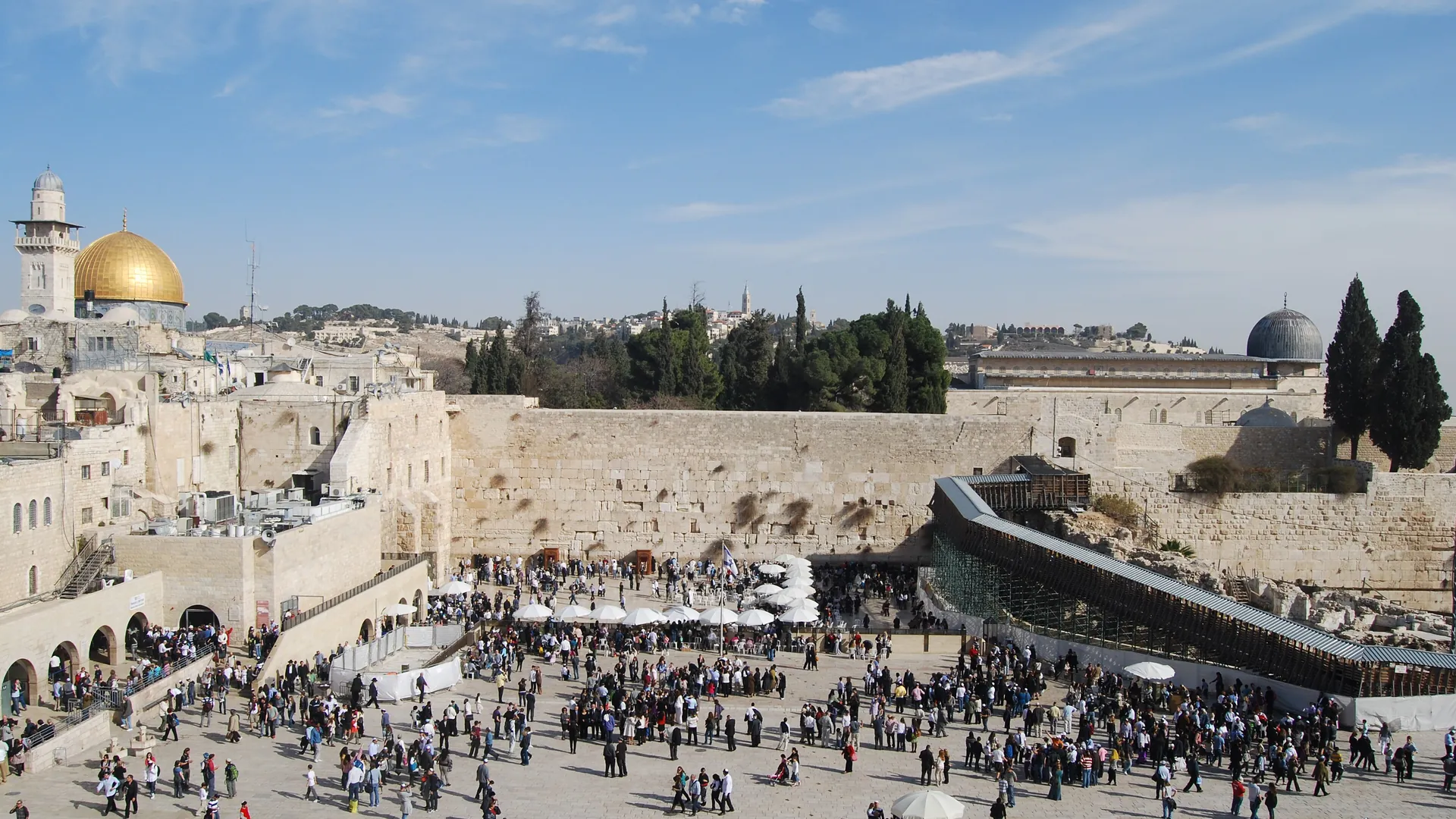 The Western Wall plaza and its crowd, with the Dome of the Rock above the wall