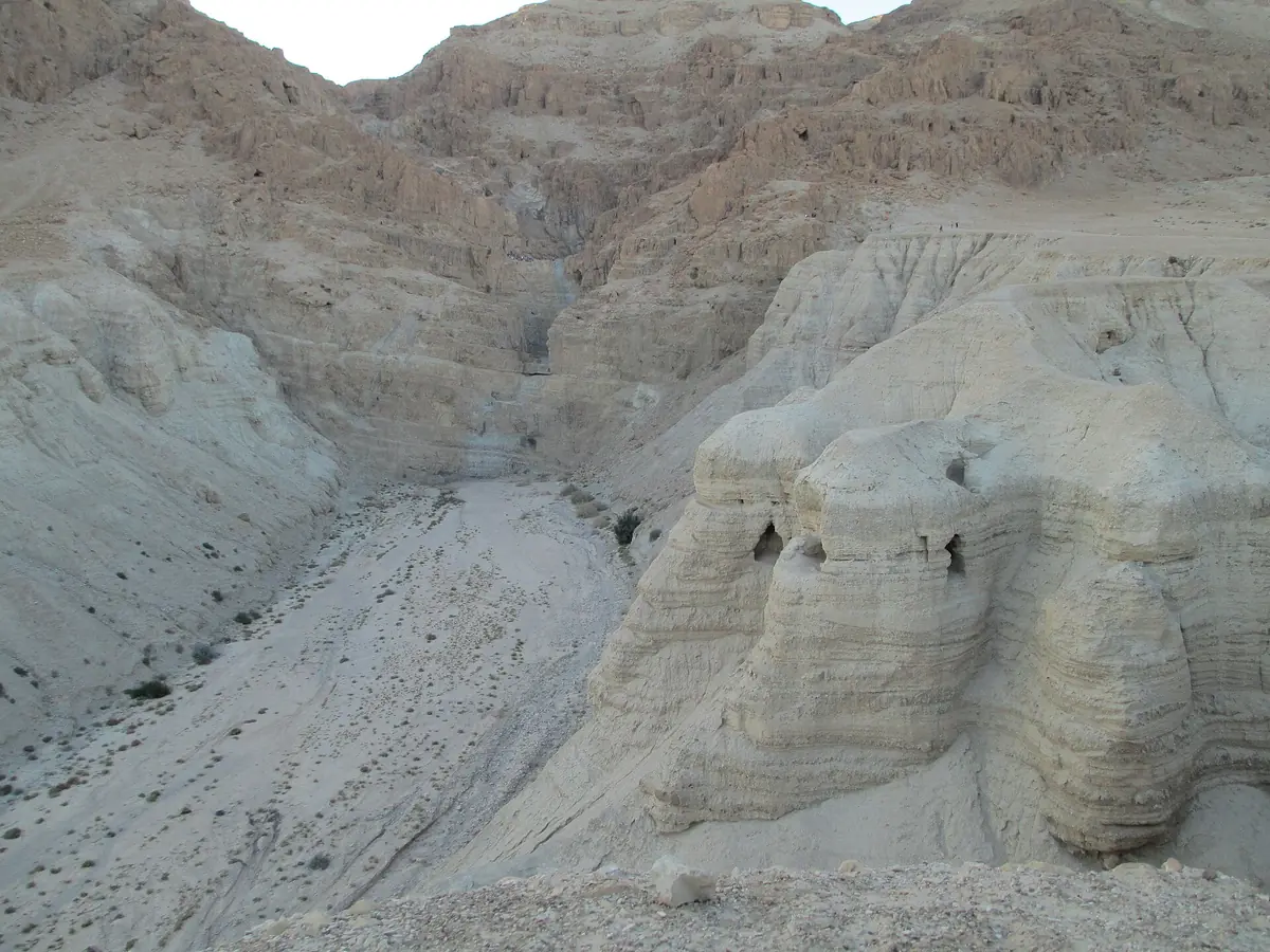 מדרגת חוואר בהירה שעוצבה בידי הסחף, ובה כמה פתחי מערות, בשולי ערוץ יבש למרגלות המצוק