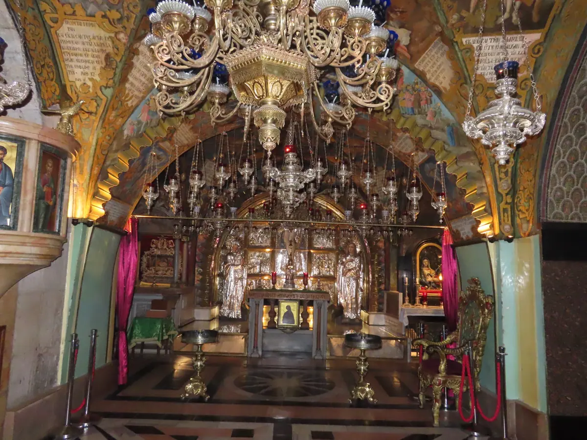 קפלה מעוטרת בעושר ובה מזבח מתחת לשפע מנורות כסף, איקונות וצלב ברקע
