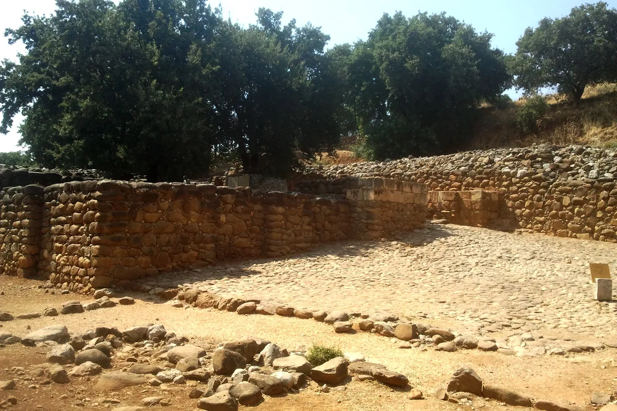 Murs de pierre et place dallée de la porte israélite de Tel Dan, à l'ombre des arbres